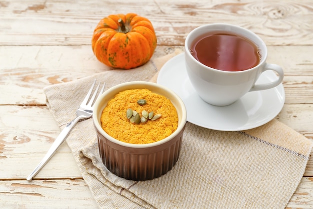 Leckerer Kürbispudding mit einer Tasse Tee auf dem Tisch