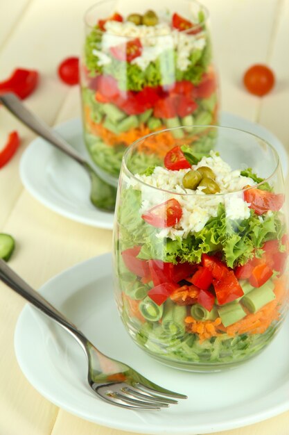 Leckerer Salat mit frischem Gemüse auf Holztisch