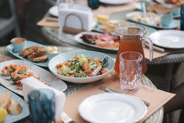 Leckerer Salat mit rotem Fisch auf dem servierten Tisch auf der Sommerterrasse im Restaurantkonzept anders