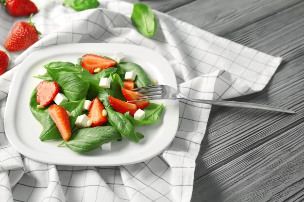 Leckerer Salat mit Spinat und Erdbeere auf Teller
