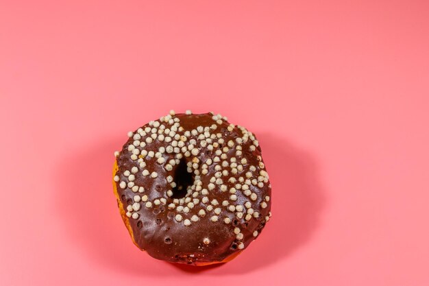 Leckerer Schokoladenkrapfen auf rosa Hintergrund