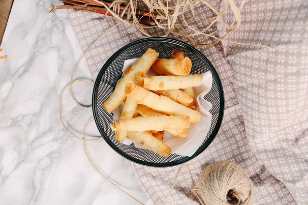 Leckerer Snackteller, Pommes Frites, Zwiebelringe, Frühlingsrollen oder Bratwürste auf dem Tisch