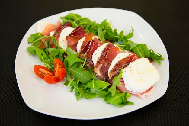 Leckerer und gesunder Salat mit verschiedenen Käsesorten und Tomaten