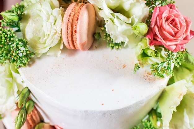 Leckerer weißer Kuchen mit Blumen und Makronen