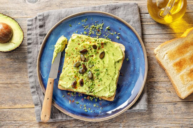 Leckeres, appetitliches Sandwichbrot mit pürierter Avocado auf dem Teller serviert.