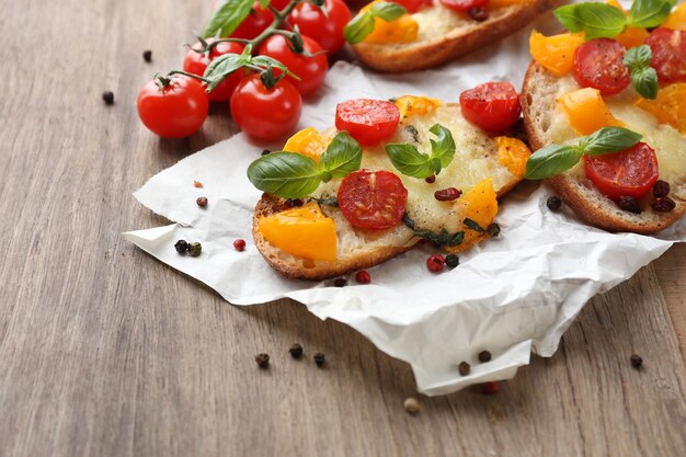 Leckeres Bruschetta mit Tomaten auf altem Holztisch