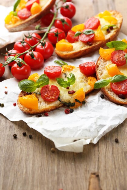 Leckeres Bruschetta mit Tomaten auf altem Holztisch