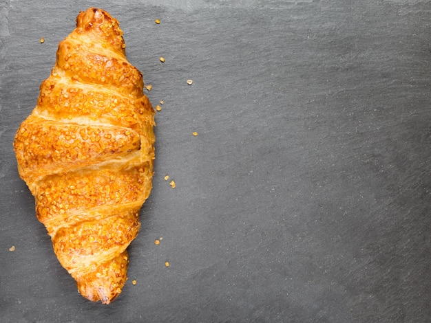 Foto leckeres croissant auf schwarzem steinhintergrund französisches essen kopieren raum zurückhaltend