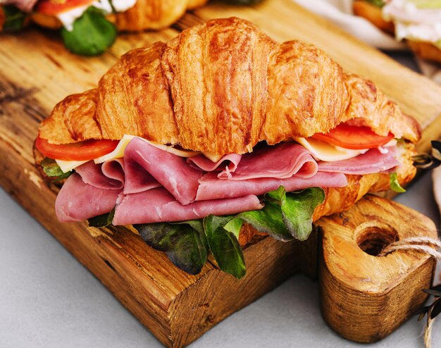 Leckeres Croissant-Sandwich auf Holzbrett