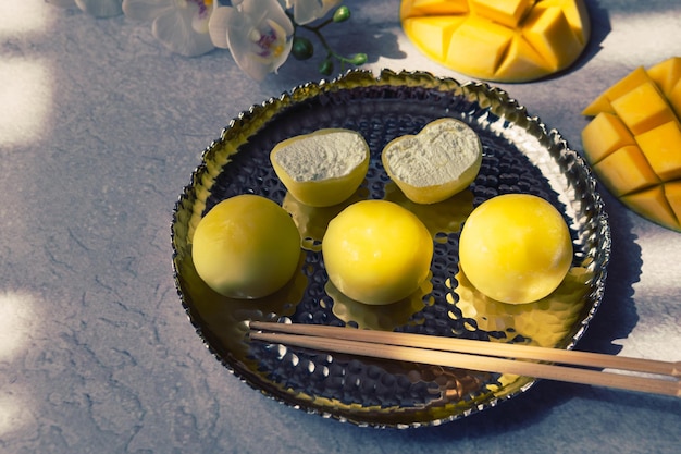 Leckeres Dessert Mochi mit Mangofrucht auf grauem Hintergrund