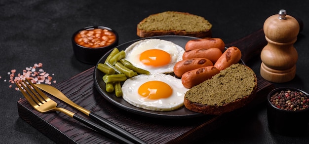 Leckeres englisches Frühstück mit Spiegeleiern, Bohnen, Spargelwürsten mit Gewürzen und Kräutern