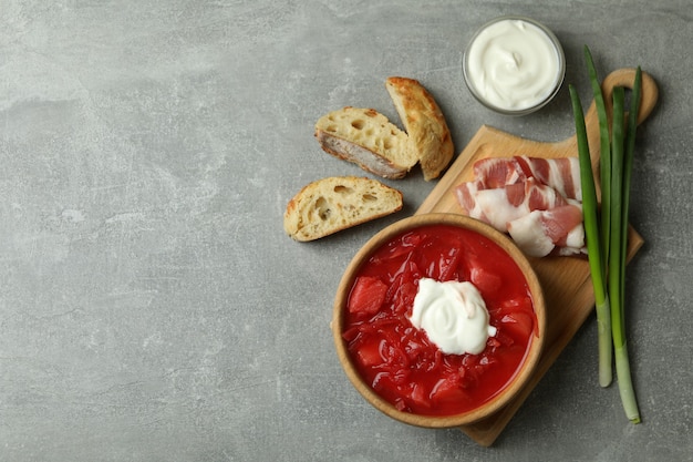 Leckeres Essen mit Borschtsch und Zutaten auf grauem Tisch