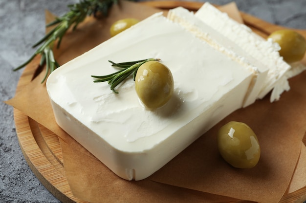 Leckeres Essen mit Feta-Käse auf grauer strukturierter Oberfläche