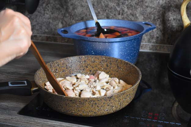 Leckeres Fleisch in einer Pfanne auf dem Herd in der Küche kochen