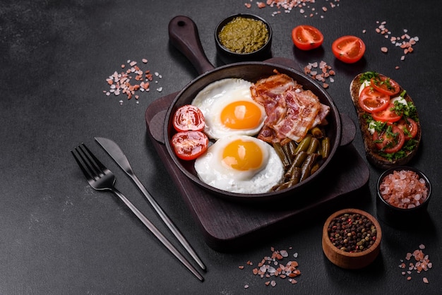 Leckeres Frühstück besteht aus Eiern Speckbohnen Tomaten mit Gewürzen und Kräutern