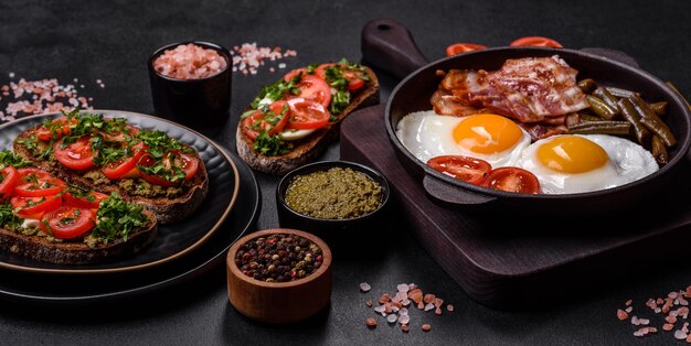 Leckeres Frühstück besteht aus Eiern Speckbohnen Tomaten mit Gewürzen und Kräutern