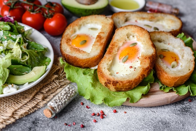 Foto leckeres frühstück mit grunzen, eiern, avocado und kirschtomaten. angenehmes morgenmahl mit frischen sandwiches