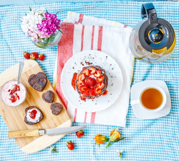 Leckeres Frühstück mit Teller mit Pfannkuchen und Erdbeeren