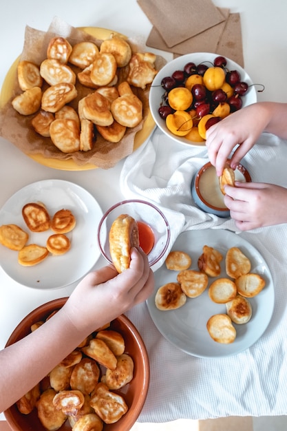 Leckeres frühstück mit winzigen mini-pfannkuchen-kirschen-aprikosen-marmelade