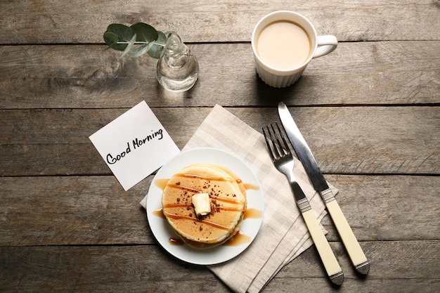 Foto leckeres frühstück und grußwort „guten morgen“ auf holztisch