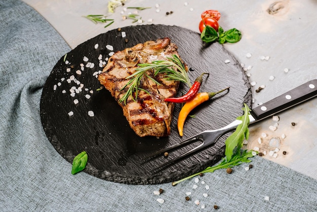 Leckeres geröstetes Steak mit Gewürzen auf Holzhintergrund