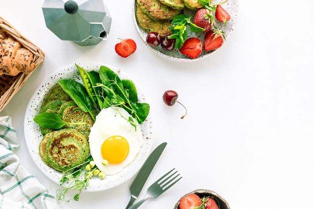 Leckeres gesundes frühstück. grüne pfannkuchen mit spinat, ei und jungen erbsen. draufsicht. speicherplatz kopieren