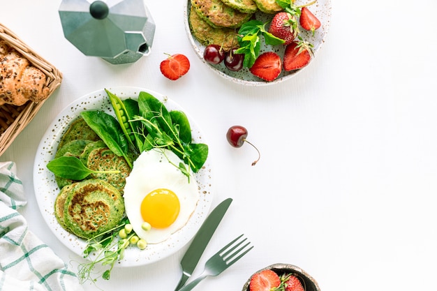 Leckeres gesundes Frühstück. Grüne Pfannkuchen mit Spinat, Ei und jungen Erbsen. Draufsicht. Speicherplatz kopieren