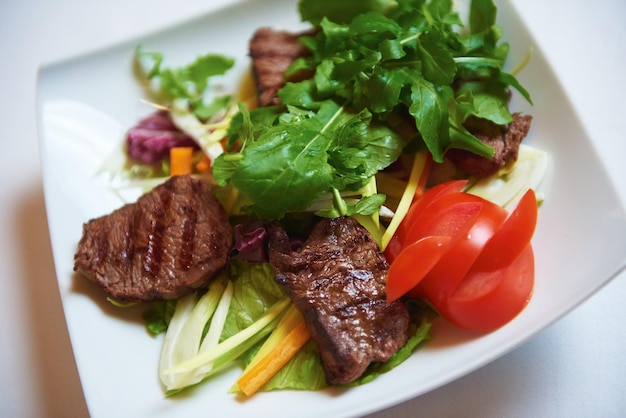 Leckeres Grillfleisch, saftiges Rindersteak mit gegrilltem Käse und Salat im Restaurant