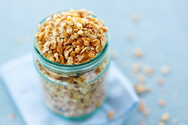 Leckeres hausgemachtes fruchtiges Müsli-Müsli im Glas auf hellem Hintergrund. Nahansicht