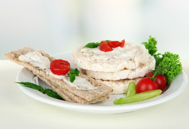 Leckeres Knäckebrot mit Gemüse auf weißem Tisch