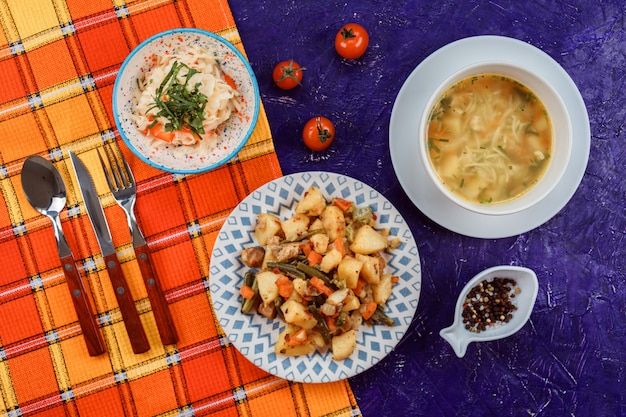 Leckeres Mittagsset aus drei Mahlzeiten, wie Suppe mit Nudeln und Karotten, Kartoffeln mit grünen Bohnen und Karotten.