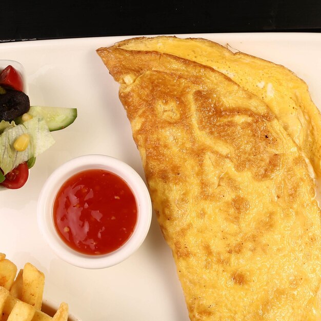 Leckeres Omelett und Frühstücksteller auf dem Tisch.