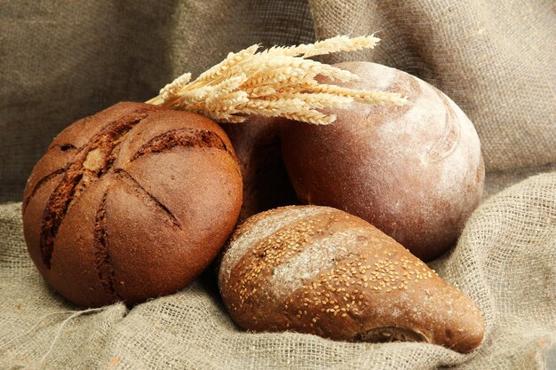 Leckeres Roggenbrot mit Ähren auf Sackleinenhintergrund