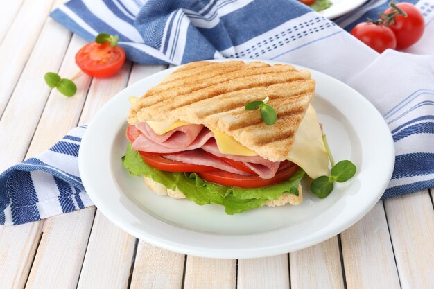 Leckeres Sandwich mit Schinken auf Holztisch