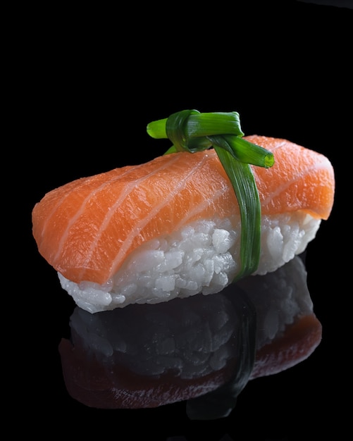 Foto leckeres sushi nigiri mit rotem fisch auf schwarzem hintergrund