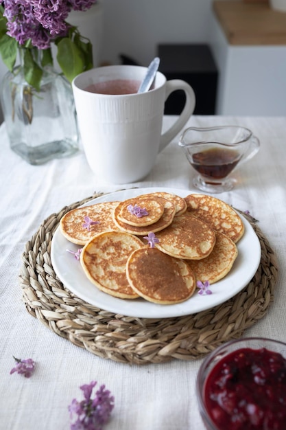 Leckeres und gesundes Frühstück mit Minipfannkuchen, Ahornsirup und Beerenmarmelade