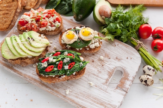 Leckeres und leckeres Bruschetta mit Tomaten, Spinat, Feta-Avocado-Paprika und Blauschimmelkäse.