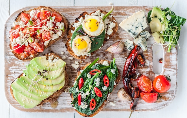 Leckeres und leckeres Bruschetta mit Tomaten, Spinat, Feta-Avocado-Paprika und Blauschimmelkäse.