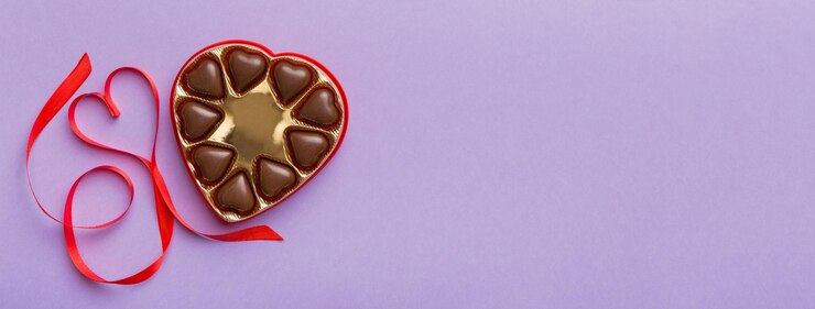 Foto leckerne schokoladenpralinen in roter schachtel für valentinstag herzförmige schokoladenkiste oberster blick mit kopierplatz