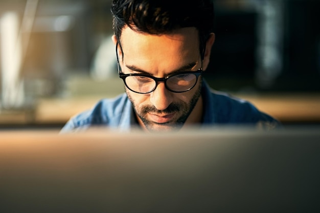 Lectura de diseño web y hombre de negocios en la computadora para investigación e revisión de Internet en la oficina Consultor creativo que trabaja hasta tarde y persona con gafas en el escritorio para planificar sitio web y en línea