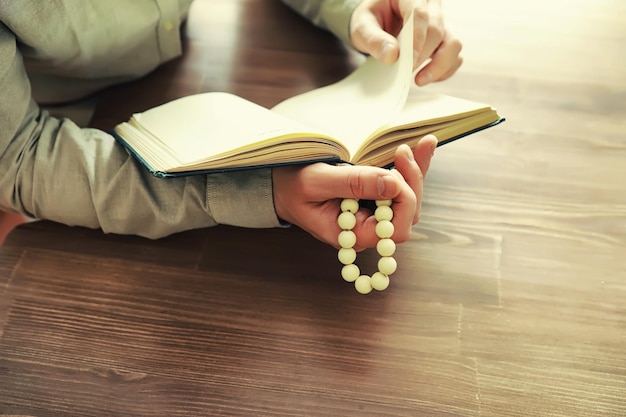 Lectura de literatura religiosa Un hombre estudia el Corán y ordena el rosario