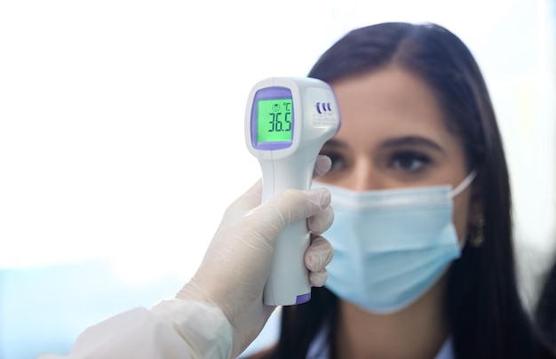 Lectura de temperatura mano y mujer con termómetro de máscara y comprobación de infección por el virus y seguridad Profesional de oficina y empleado con examen o prueba de corona médico y ciencia para el lugar de trabajo