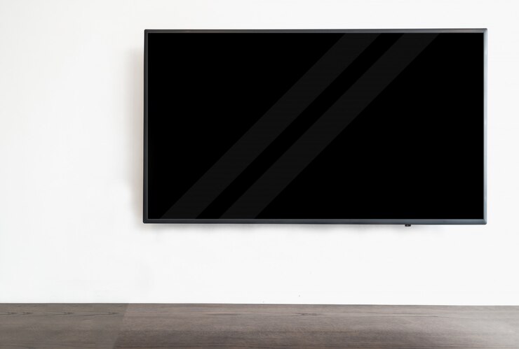 Foto led tv inteligente colgada en el fondo de pared blanca, con mesa de madera.