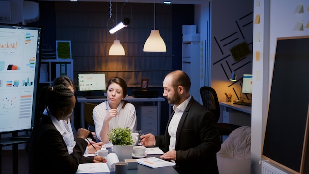 Leder empresária sentada na mesa analisando apresentação de marketing e discutindo dados financeiros