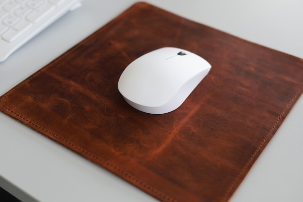 Foto leder mousepad isoliert auf schreibtisch mit weißer maus