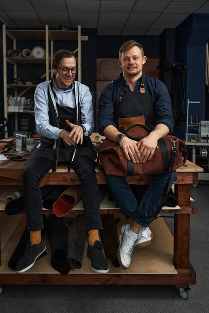 Foto lederhandwerker, die am tisch im werkstattstudio mesupenets in mustern herstellen