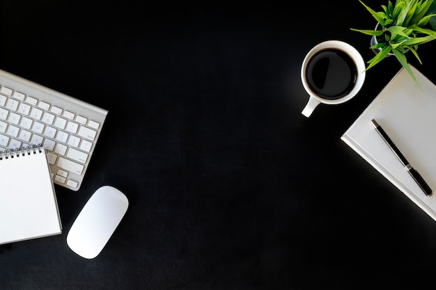 Lederne Schreibtischtabelle des Büros mit Laptop-Computer, Versorgungen, Kaffeetasse und Blume.