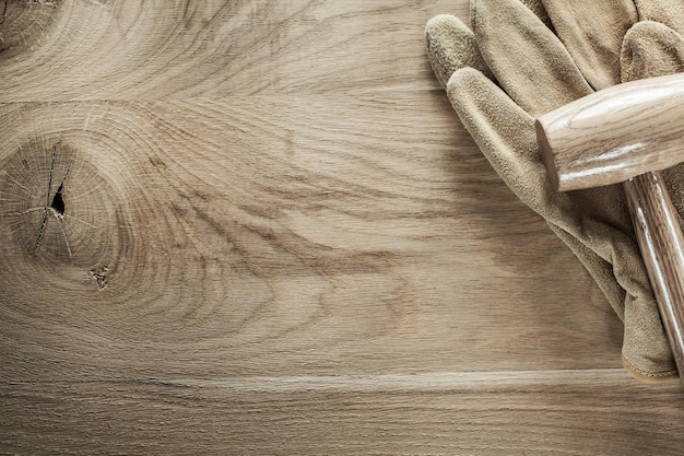 Lederschutzhandschuhe Holzhammer auf Holzplatte