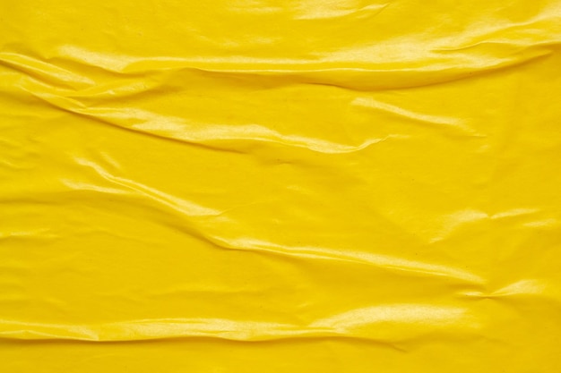 Leer gelber, zerknitterter und gekrümmter Papierposter-Hintergrund