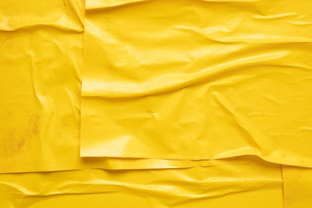 Foto leer gelber, zerknitterter und gekrümmter papierposter-hintergrund